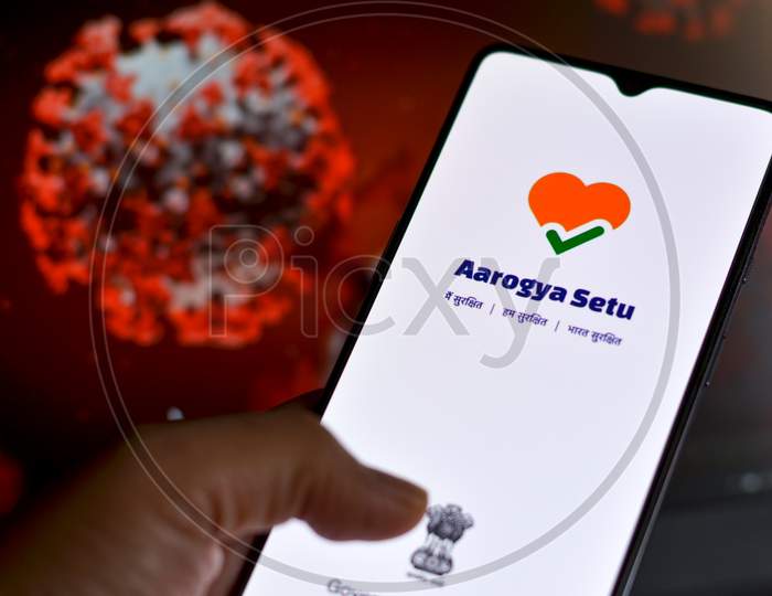 New Delhi, India, 2020. Aarogya Setu App, Developed By Government Of India To Track The Covid-19 Status, Logged In On A Mobile Infront Of A Screen Showing Microscopic 3D Illustration Of Corona Virus
