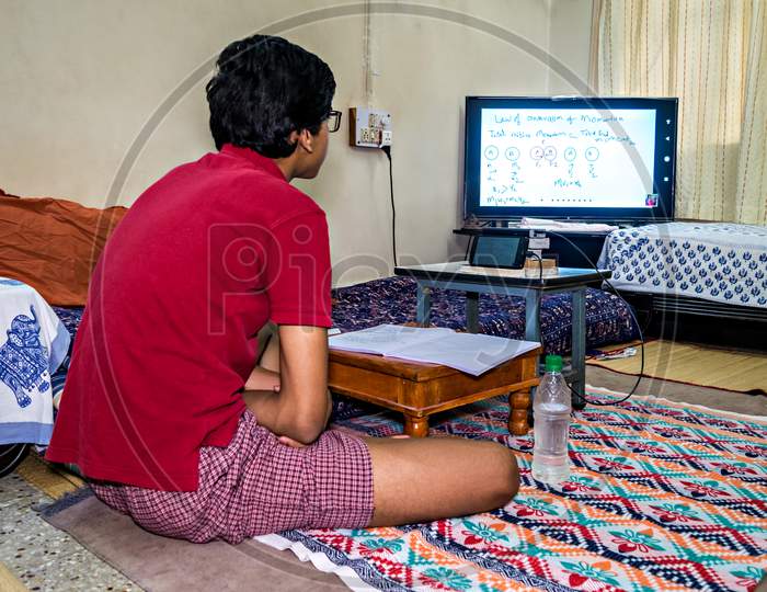 Pune, India - June 2nd, 2020 : Student pursuing online education through cell phone due to closed schools on account of spread of pandemic COVID-19, corona virus in Pune, Maharashtra, India.