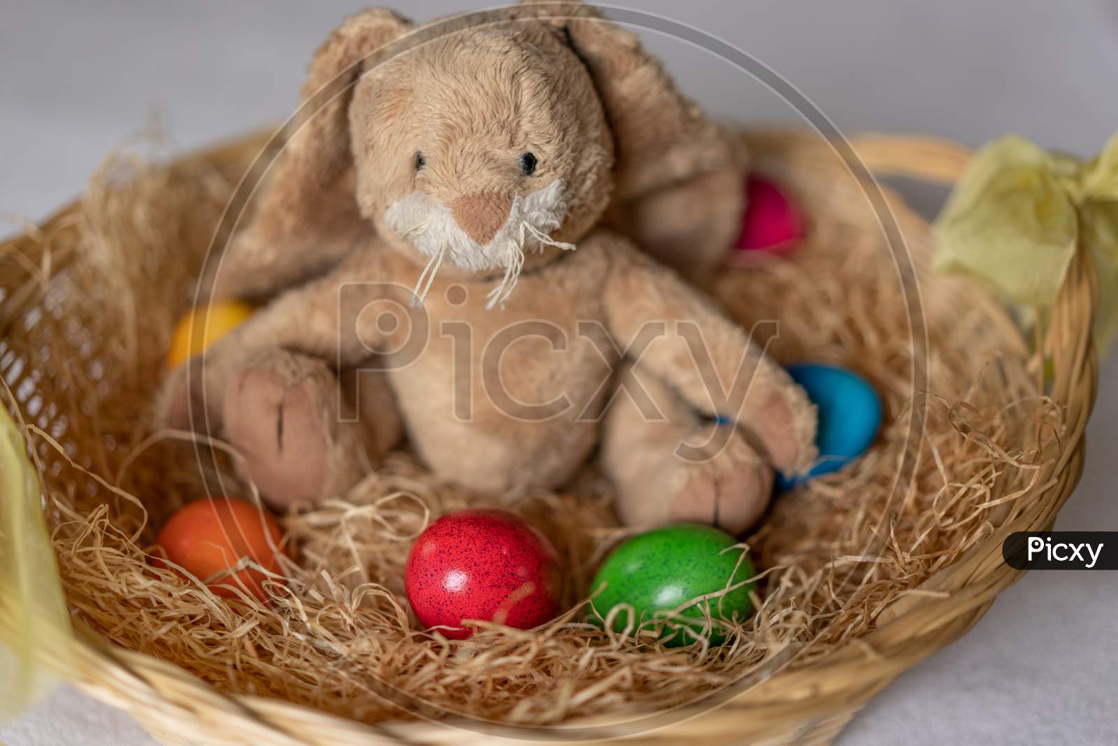 Stuffed Easter Bunny In Hay Basket And Eggs.