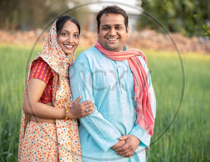 Happy Indian Rural Farmer Couple In Agricultural Field.