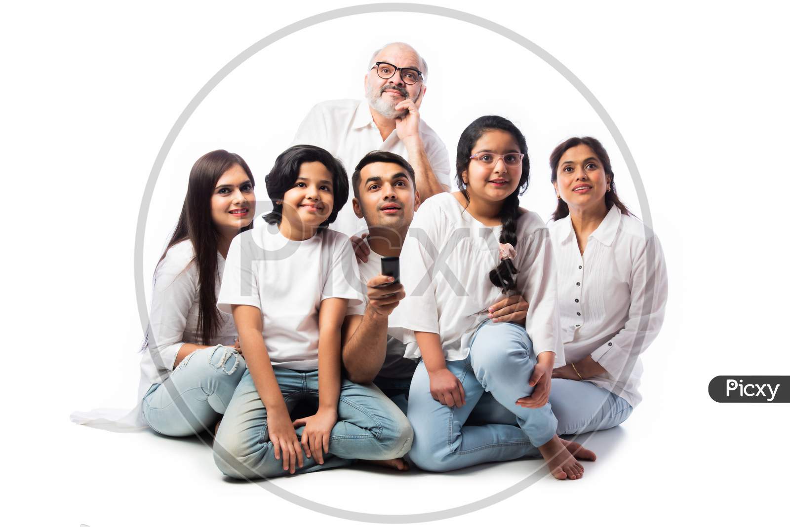 Indian Asian Family Watching Tv, Holding Remote Control, Sitting Against White Background
