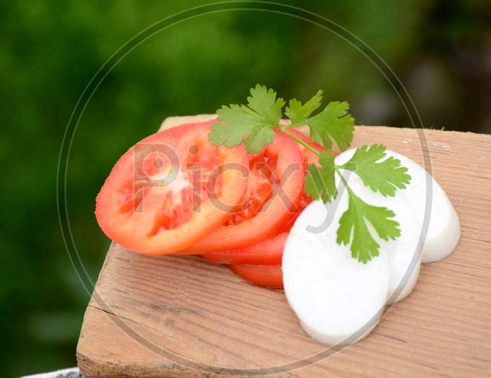 The Red Tomato With White Radish Sliced And Green Coriander On The Green Brown Wooden Background.