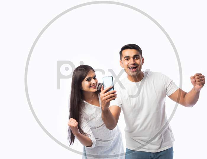 Indian Asian Smart Young Couple Holding Using Smartphone Against White Background