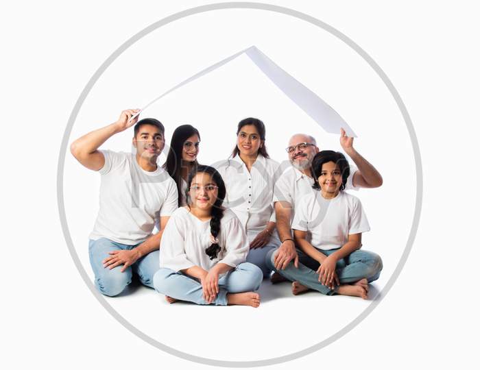 Asian Indian Family Of Six Holding Paper House Model With Keys, Isolated Against White Background