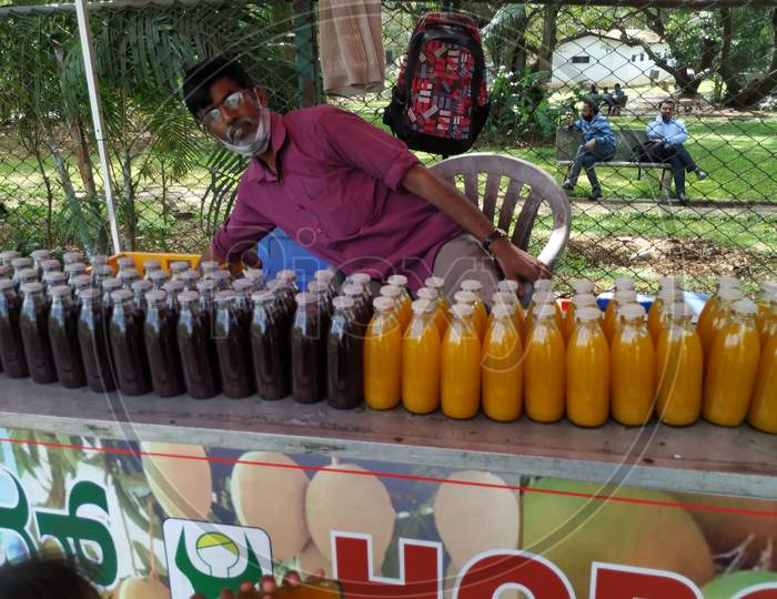 Closeup Of Man Selling Grapes And Mango Juices In A Bottle At Cubbon Park