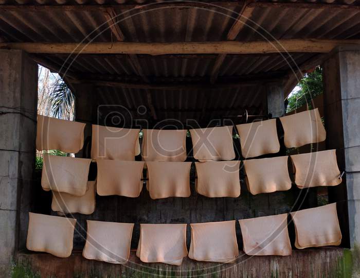 Rubber sheets hung for drying in a production unit at a rubber plantation