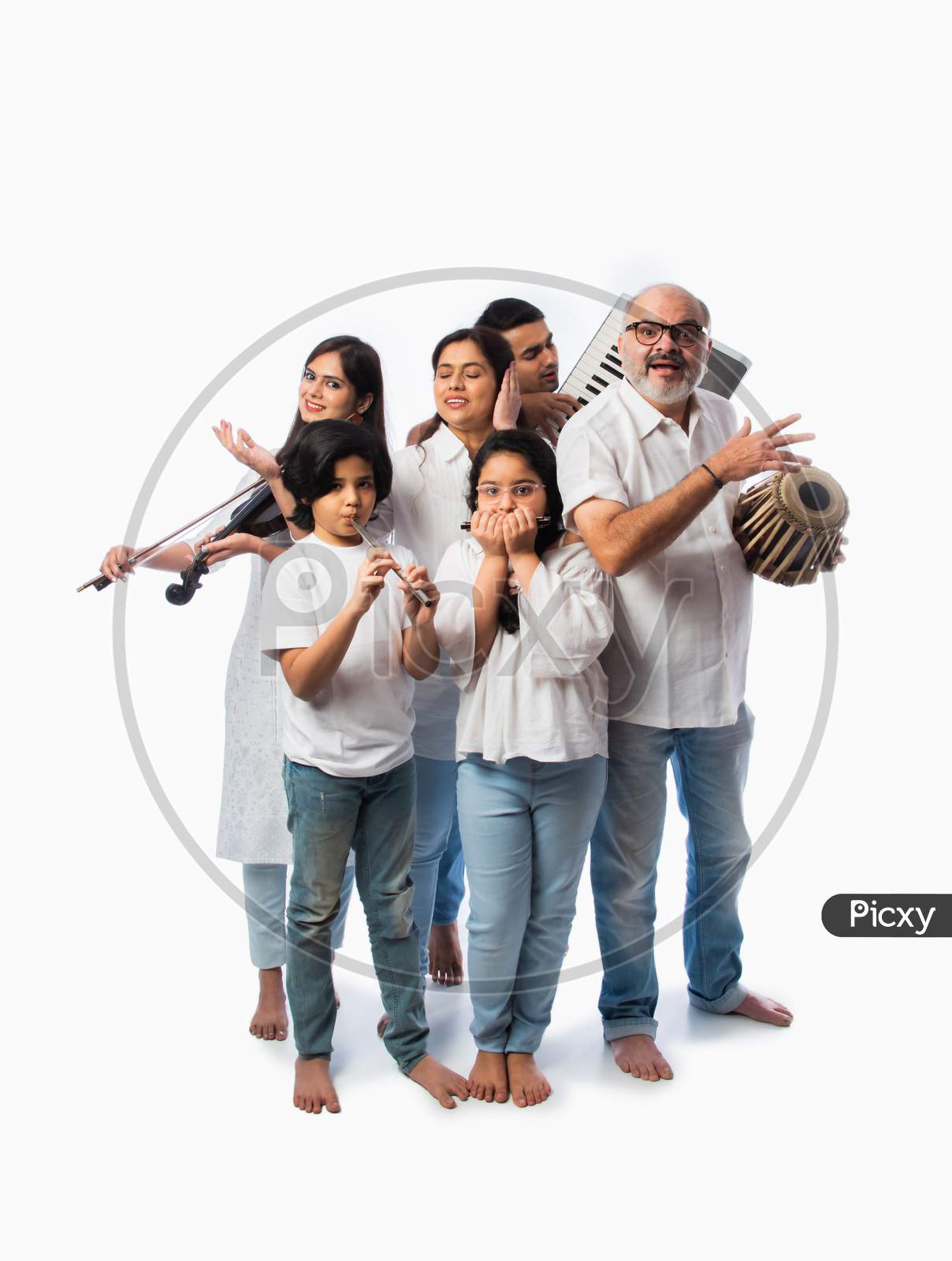 Indian Family Playing Music Instruments Together As A Band, Performing Against White