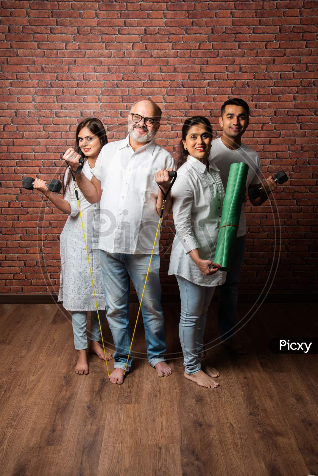 Indian Asian Family Exercising Together At Home - Healthy Lifestyle Concept