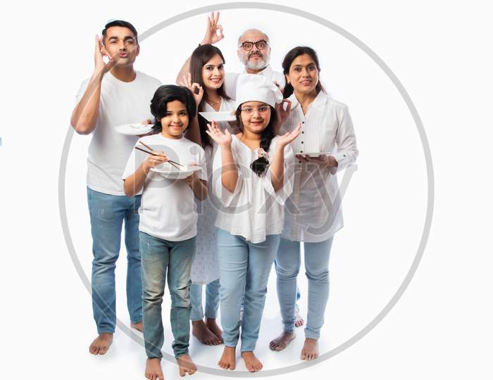 Concept Showing Indian Asian Little Girl Chef Posing With Family Holding Empty Plates And Bowl