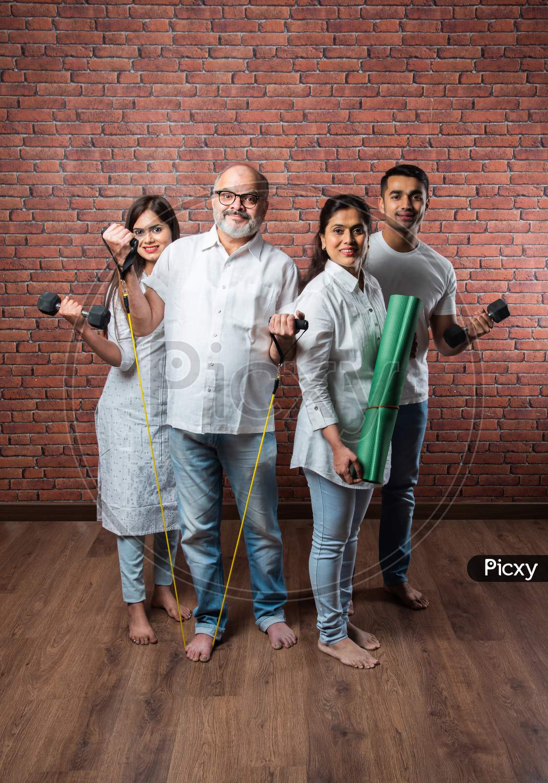Indian Asian Family Exercising Together At Home - Healthy Lifestyle Concept