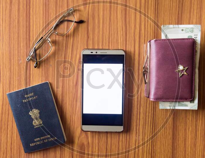 Business Still Life Concept. Personal Accessories On Table Desk. Indian Passport, Money Purse, Paper Currency, Eye Glasses And Mobile Phone With Blank Screen. Top View With Copy Space For Text. Mockup