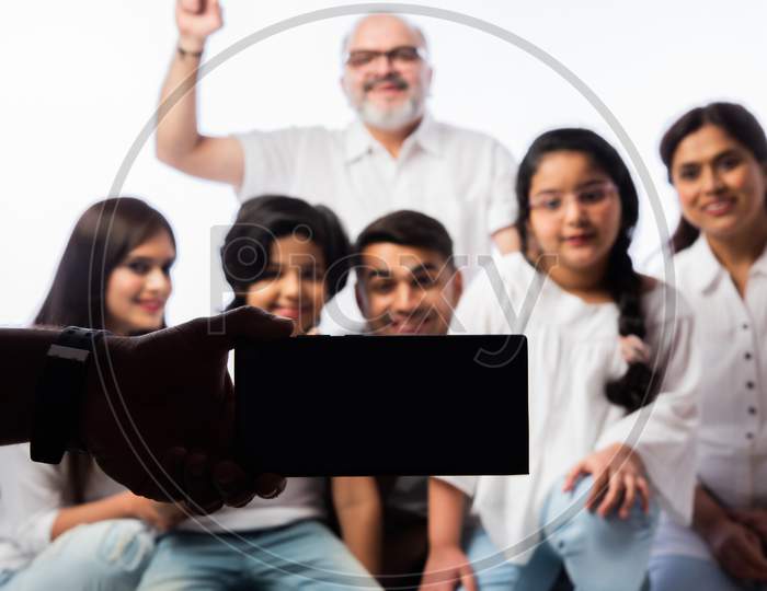 Indian Asian Multigenerational Family Using Smartphone For Selfie Or Video Calling