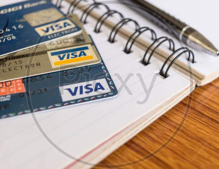 Goa India, 1 May 2019 - Close Shot Of Pile Of Visa Brand Credit Card, A Pen And Blank Application Form Paper Filling Document On Table. Shopping Online Or Pay Payment Business Concept. Shallow Focus.
