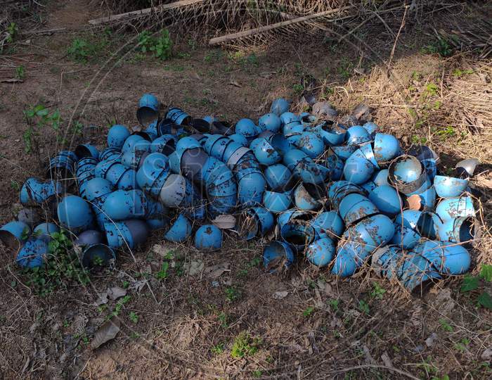 Plastic cups used for rubber tapping, laid on ground after usage