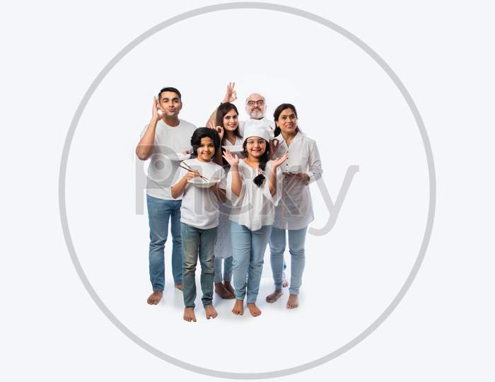 Concept Showing Indian Asian Little Girl Chef Posing With Family Holding Empty Plates And Bowl
