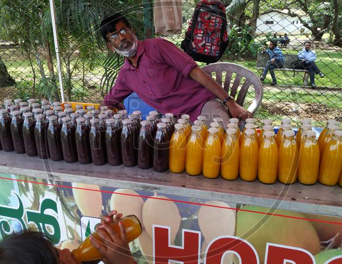 Closeup Of Man Selling Grapes And Mango Juices In A Bottle At Cubbon Park