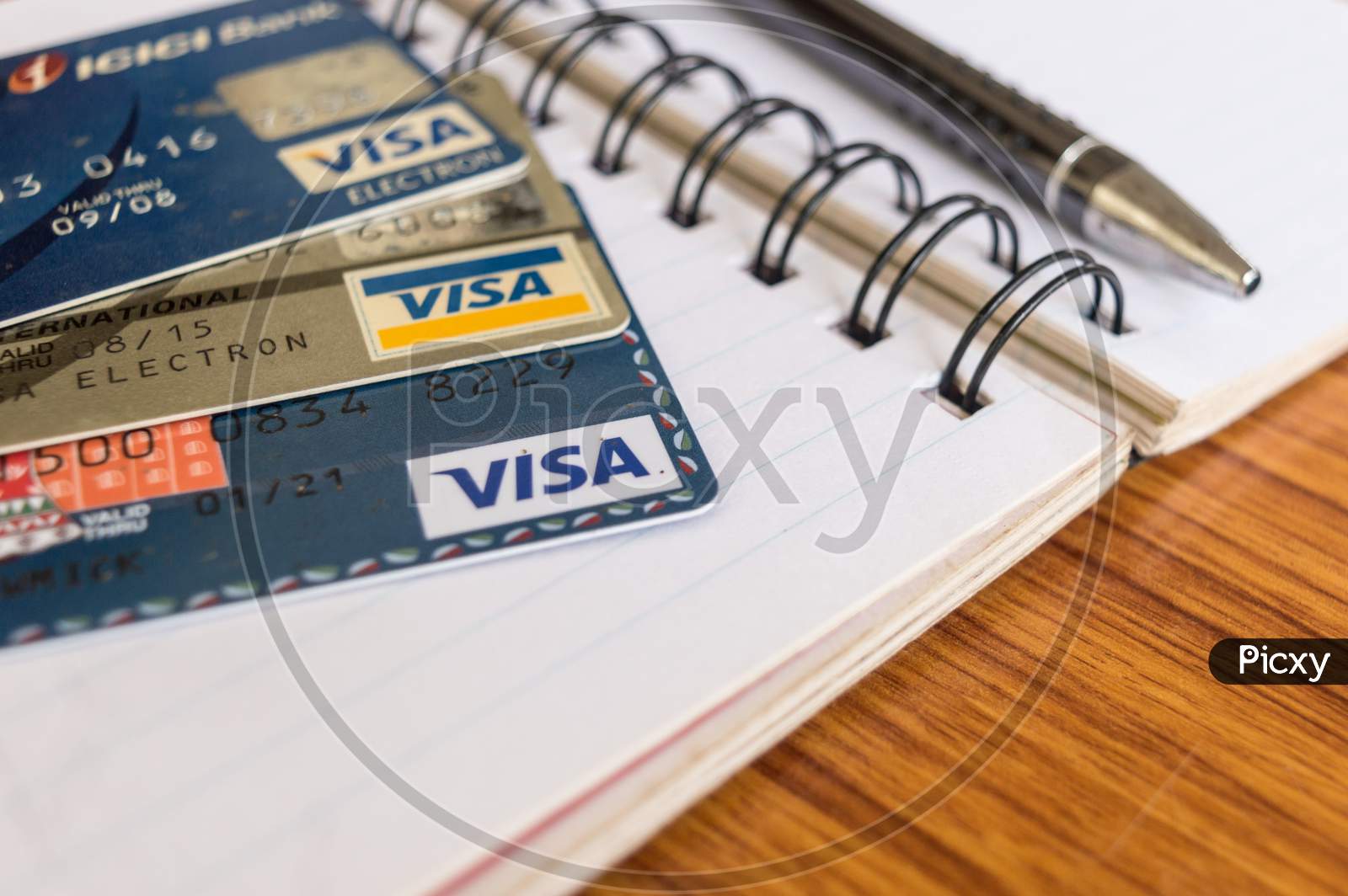 Goa India, 1 May 2019 - Close Shot Of Pile Of Visa Brand Credit Card, A Pen And Blank Application Form Paper Filling Document On Table. Shopping Online Or Pay Payment Business Concept. Shallow Focus.