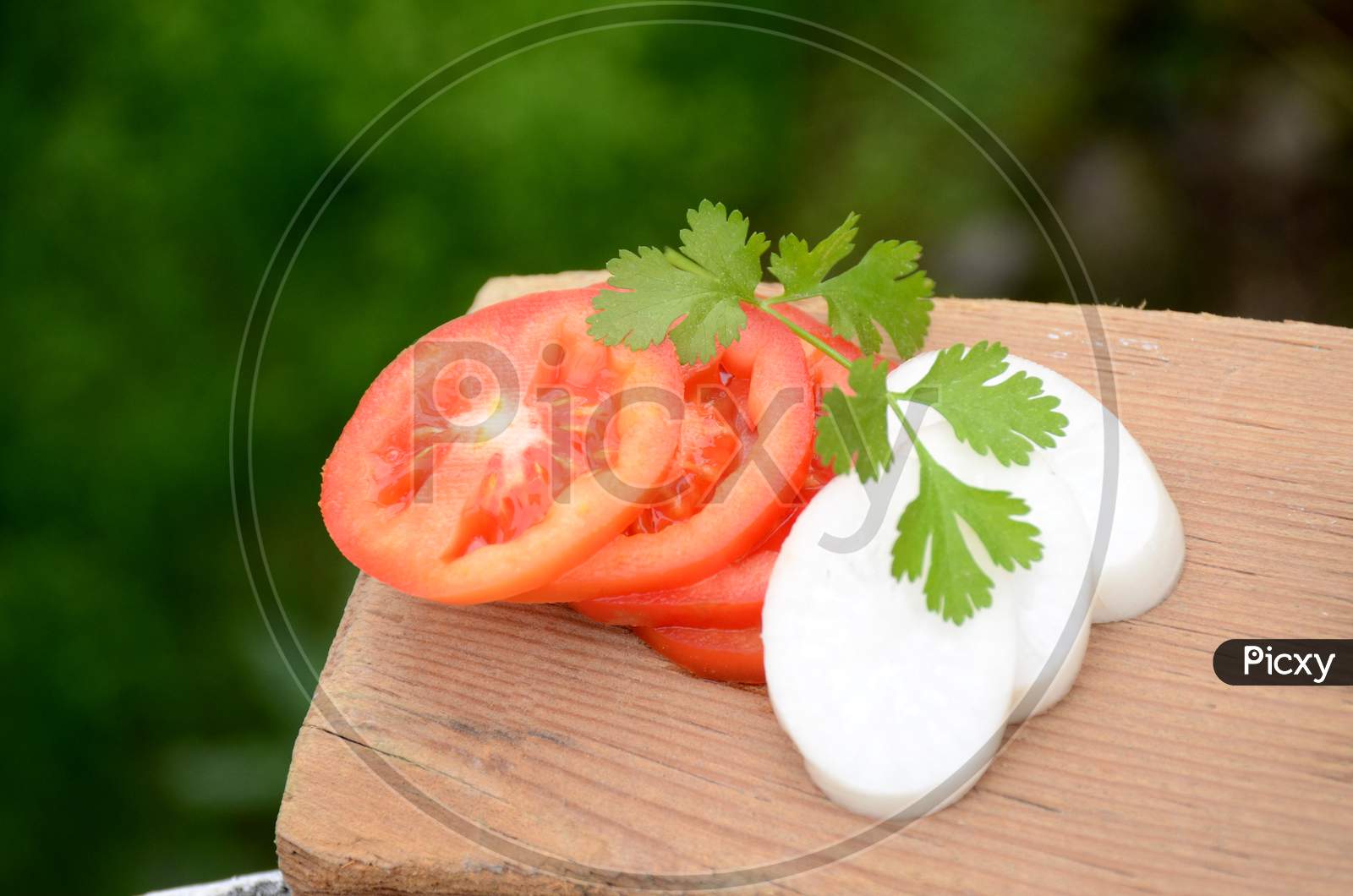 The Red Tomato With White Radish Sliced And Green Coriander On The Green Brown Wooden Background.