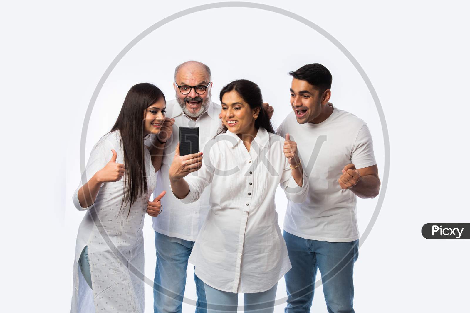Indian Family Using Smartphone, Includes Young Couple And Senior Adults