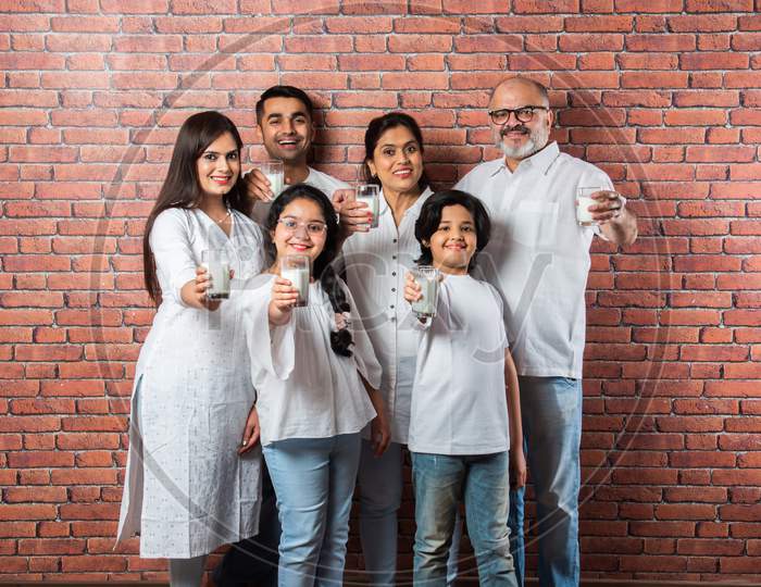 Indian Asian Family Of Six Drinking Milk In A Glass