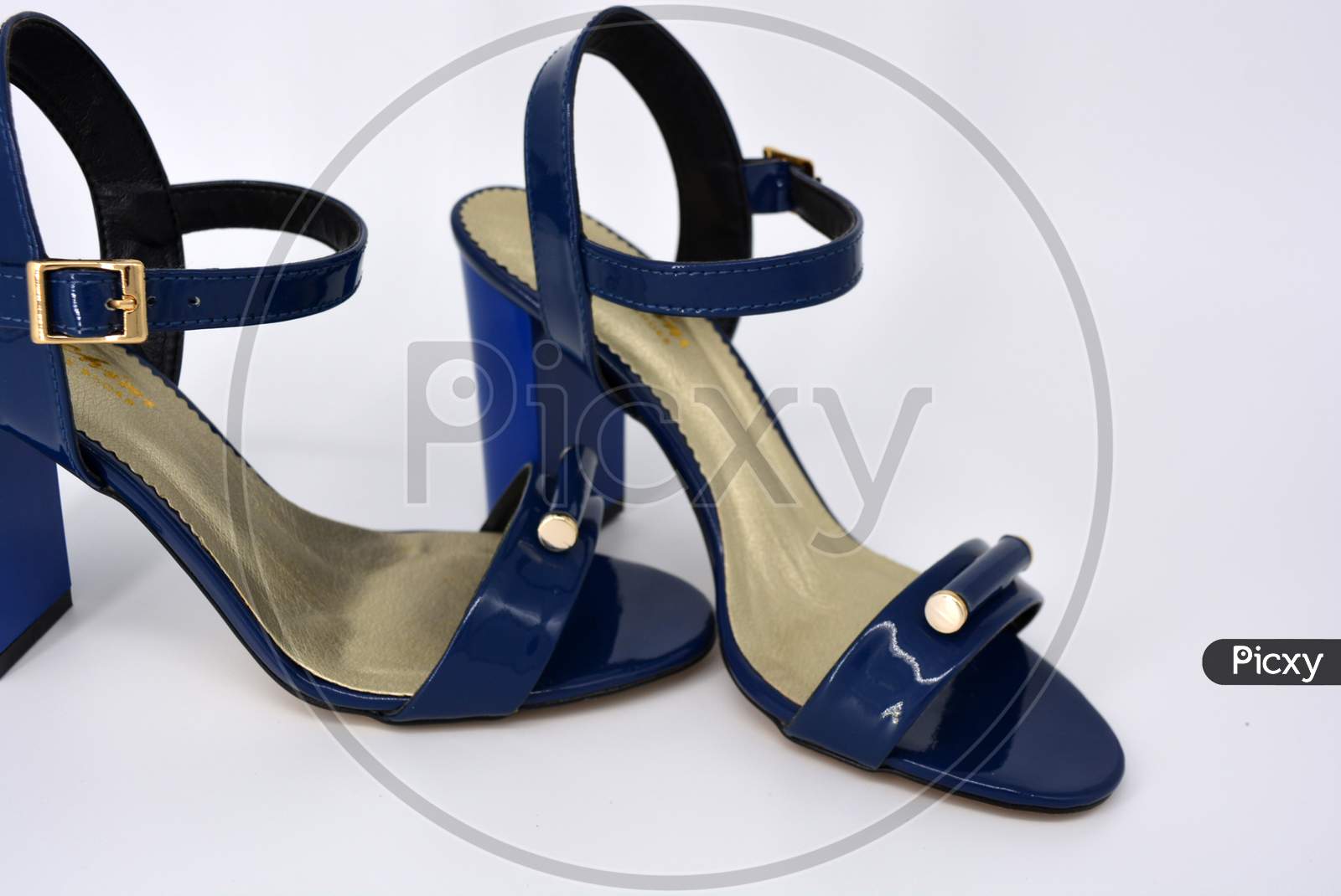 One thing, one pair of female blue lacquer sandals on a wide heel with a golden insole located on a white background.