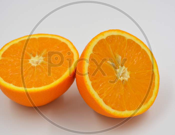 Useful and delicious fruits for human health. Orange oranges cut into two halves. Juicy fresh fades of orange with bones.
