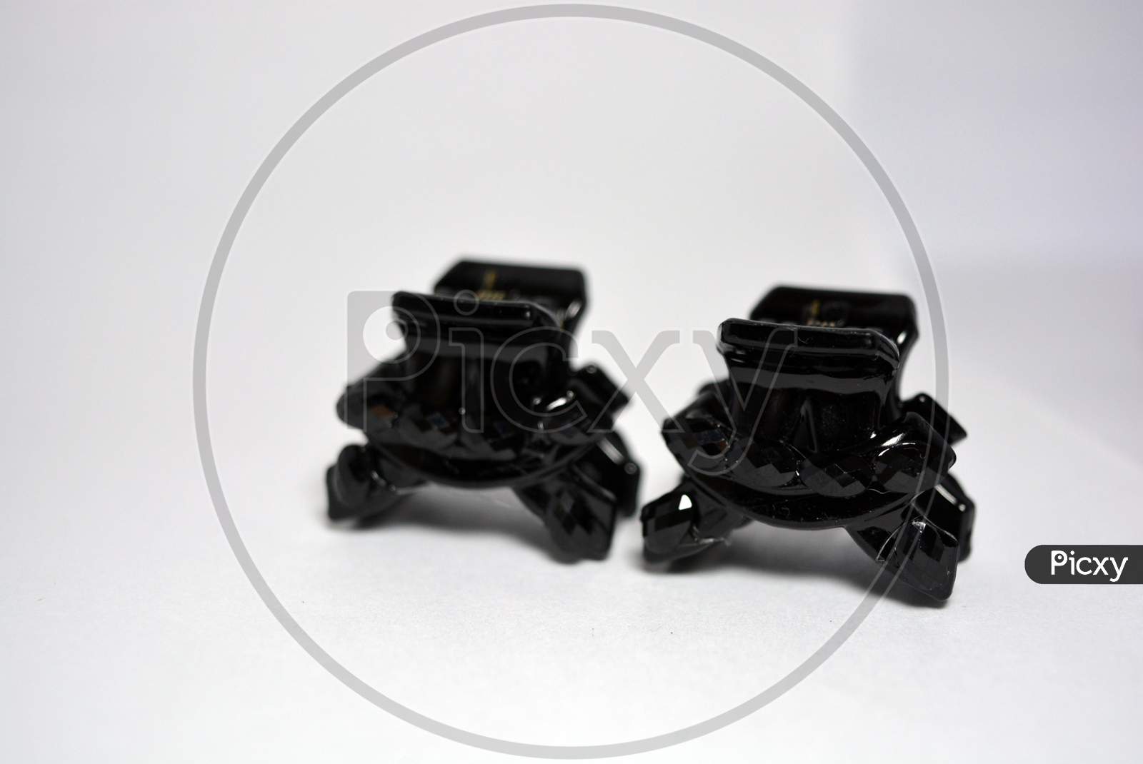 Beautiful and elegant female hair clips, black crabs decorated with black small stones, located on a white background.