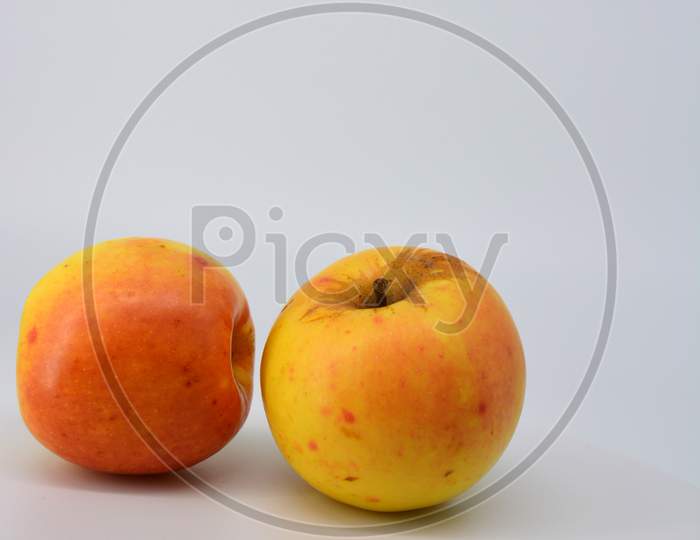 Small ripe yellow apples with red sideways located on a white background.