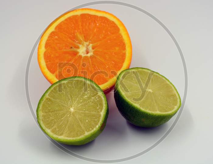 Healthy ripe delicious fruits for human health. Juicy fruits of orange orange, lime. Two halves of lime, one half of an orange located on a white background.