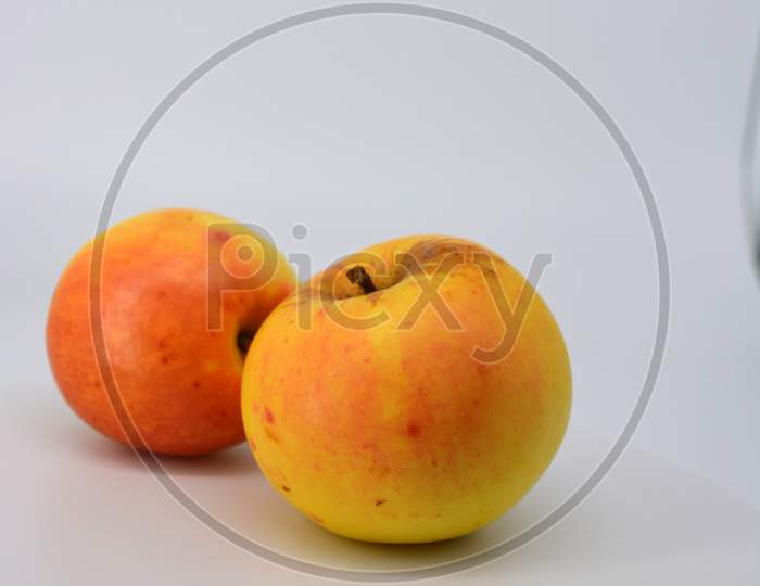 Small ripe yellow apples with red sideways located on a white background.