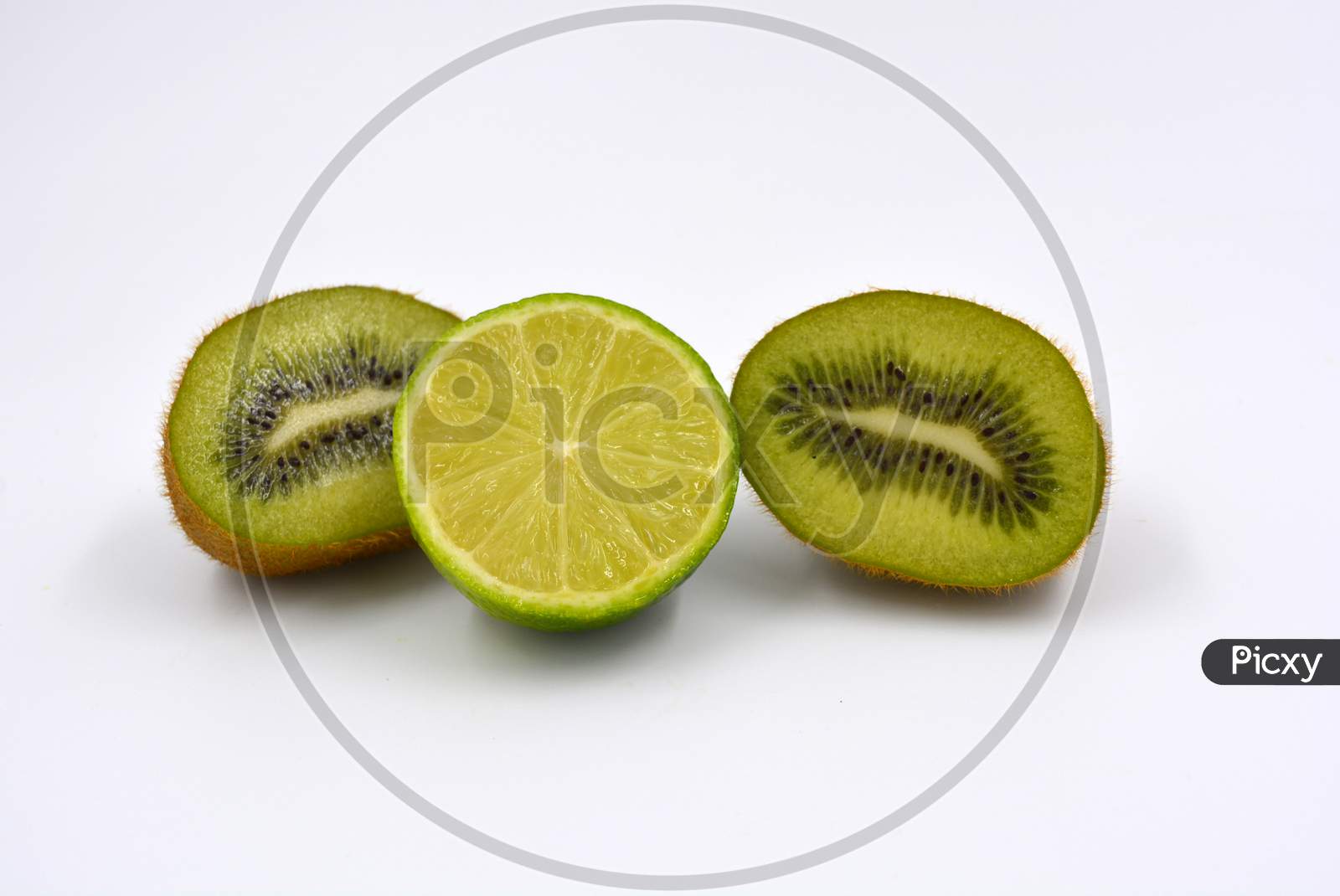 Healthy ripe delicious fruits for human health. Juicy fruits of brown kiwi with limes. Two kiwi halves with one lime half are located on a white background.
