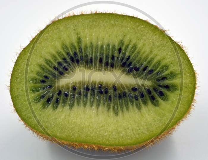 Healthy ripe delicious fruits for human health. Green kiwi fruits arranged on a white background. The whole kiwi is cut into one even piece.