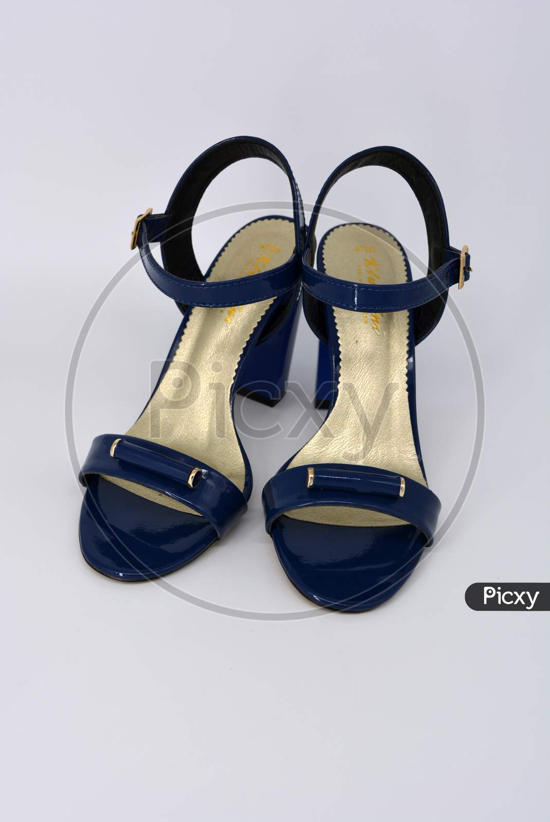 One thing, one pair of female blue lacquer sandals on a wide heel with a golden insole located on a white background.