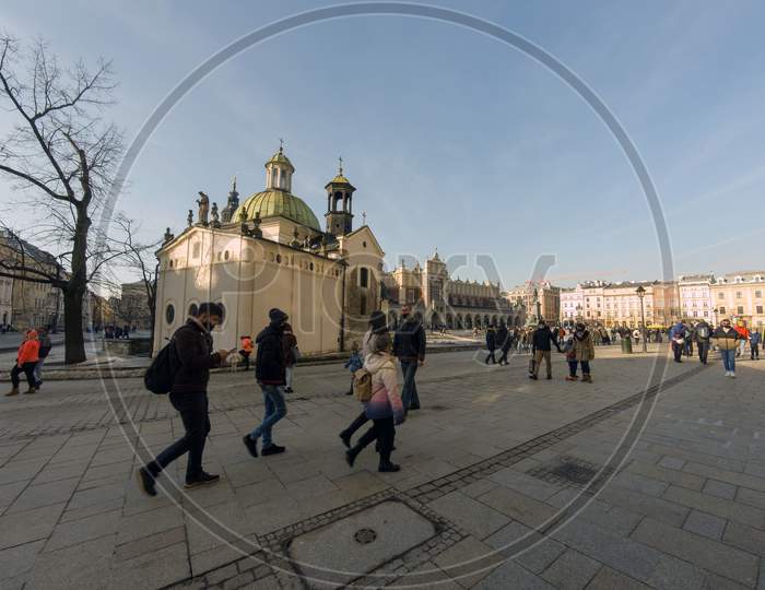 Krakow, Poland - February 20, 2021: Wide Angle Shot Of A Cracow City Center And People Taking A Walk In Mask During Covid Pandemic In The Old Town Of Cracow City.