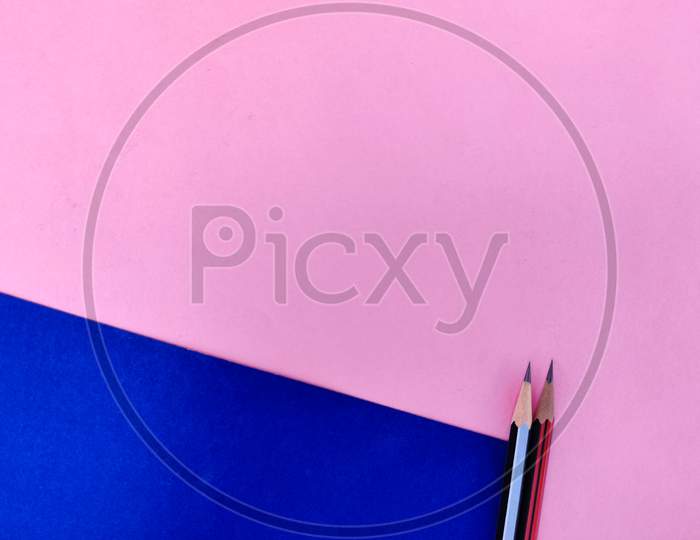 Copy Space Of Two Sharp Pencils In Black And Red Color Isolated On Pink And Blue Background