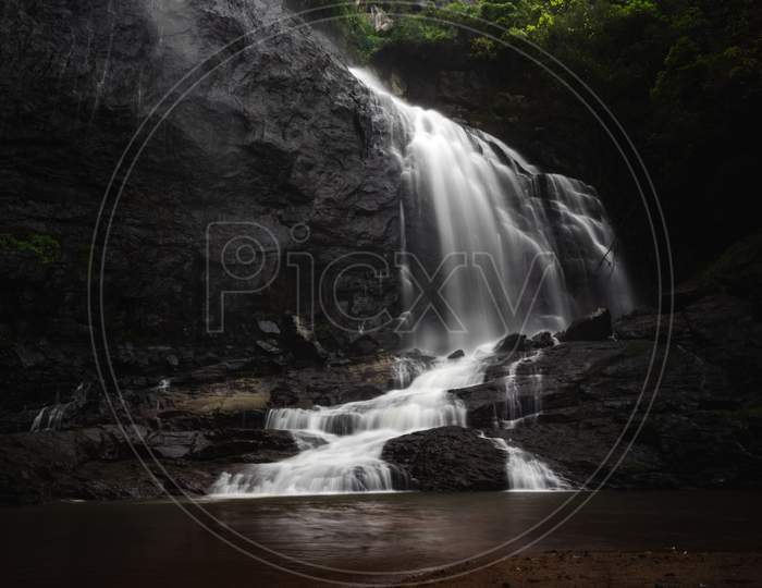 Beautiful Waterfall Landscape - A Long Exposure Of A Waterfall Flowing Down Into A Pool Of Cold Water. Beautiful Hidden Waterfall In Tropical Rainforest. Slow Shutter Speed, Motion Photography.