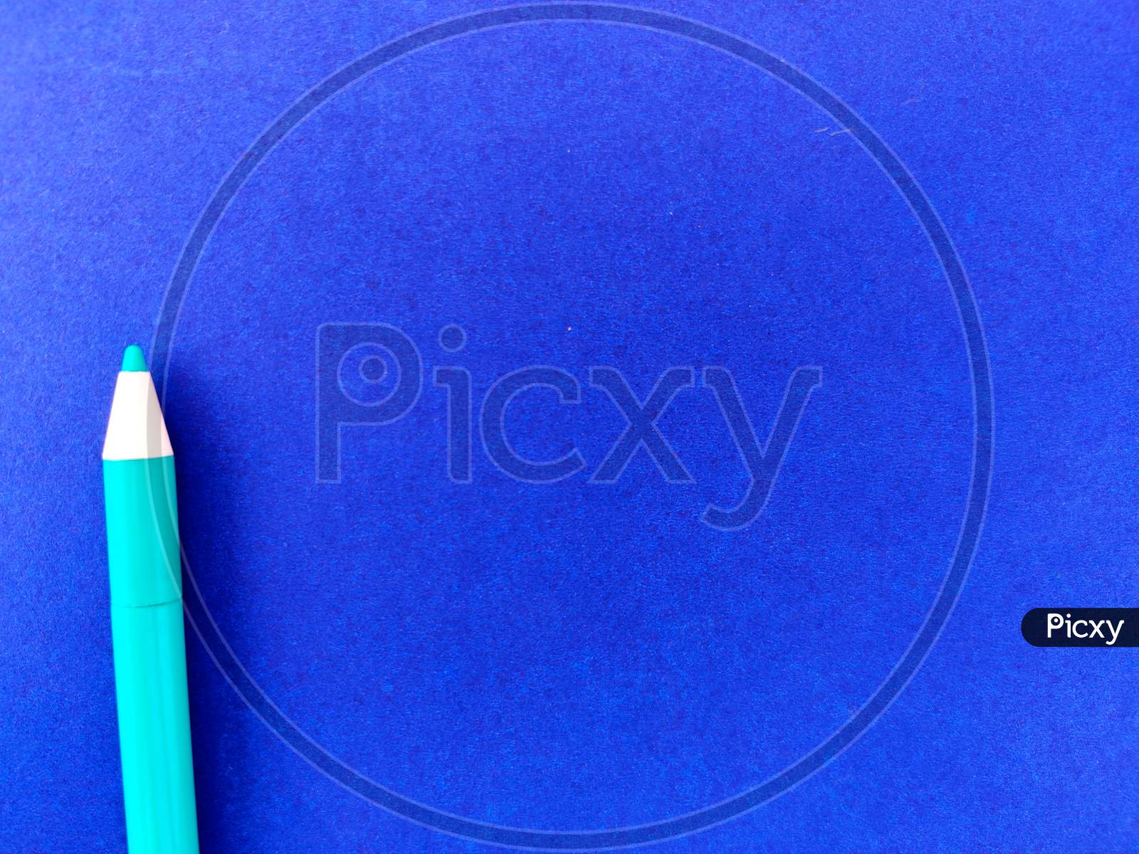 Copy Space Of Green Ink Pen Isolated On Blue Background.