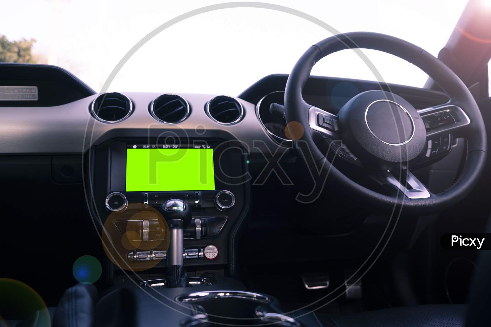 Interior Of A Luxury Car With Black Leather Finish, With A Green Screen On The Dashboard. Man Driving The Car.