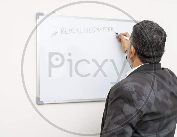 A Man Writing Black Lives Matter On A White Board. Teacher Teaching About Black Lives Matter.