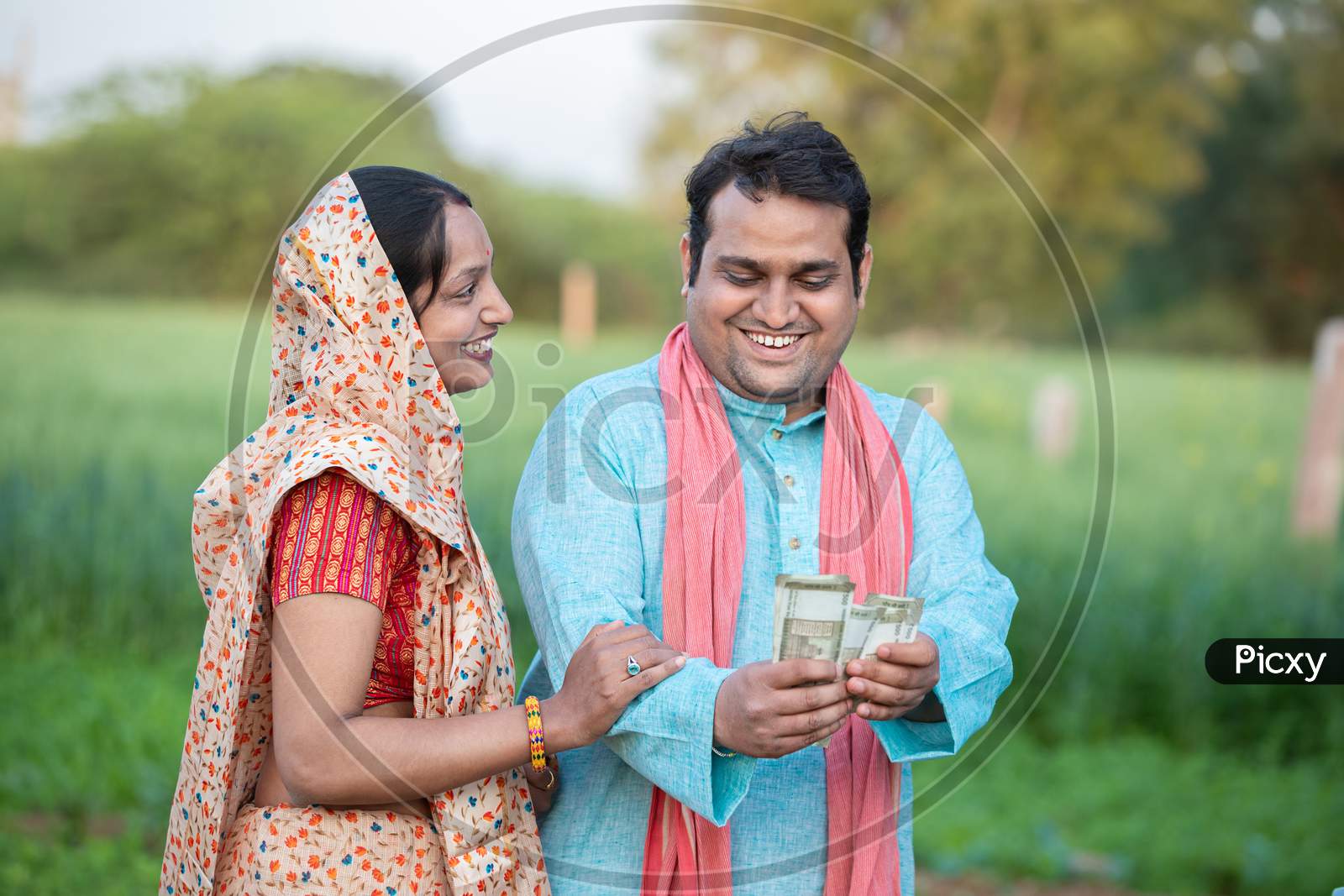 Happy Indian Farmer Couple Counting Rupees Note At Agriculture Field, Man Holding Money.