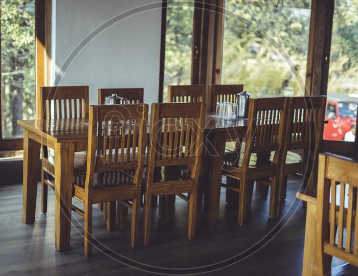 Long Shot Of A Dining Table With Glasses, Fork, Jugs On The Top Of The Table. Captured Interior Of A Restaurant.