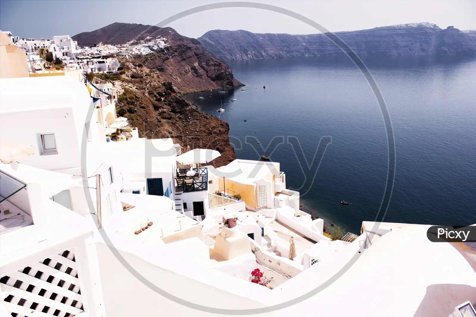 Santorini, Greece Beautiful city of Oia on a hill of white houses with blue  roof against dramatic pink sky, located in Greek Cyclades islands in Mediterranean  sea Beach Towel by Arpan Bhatia 