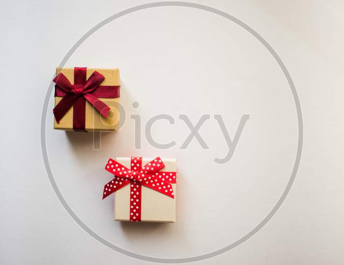 Two Small Gift Boxes With Tied Decorative Bow And Red Ribbon