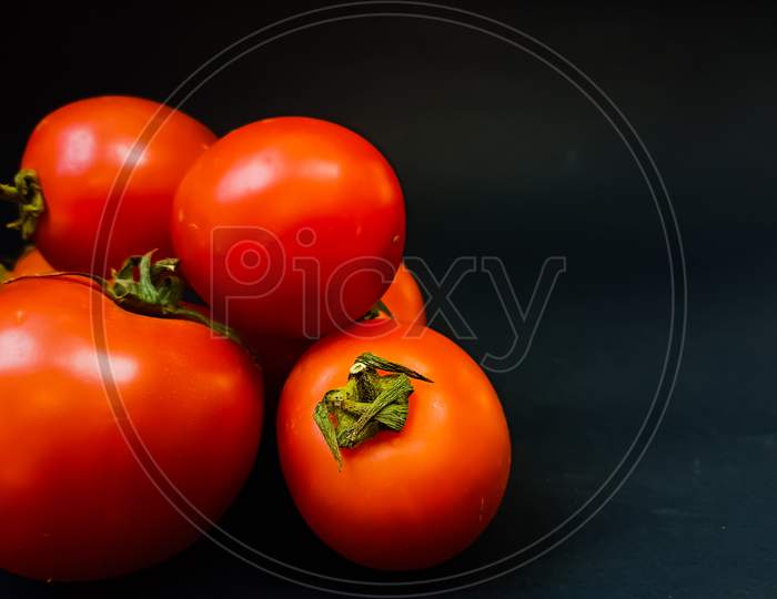 Red tomato on black background
