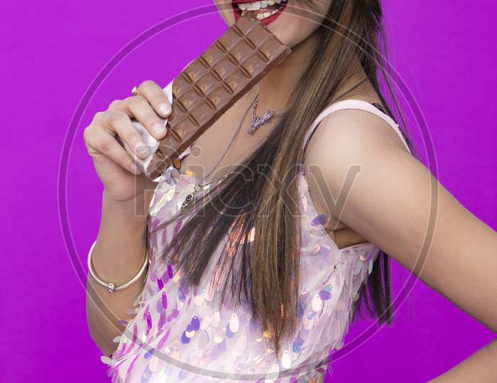 A Beautiful girl eats chocolate and posed with chocolate Chocolate Day