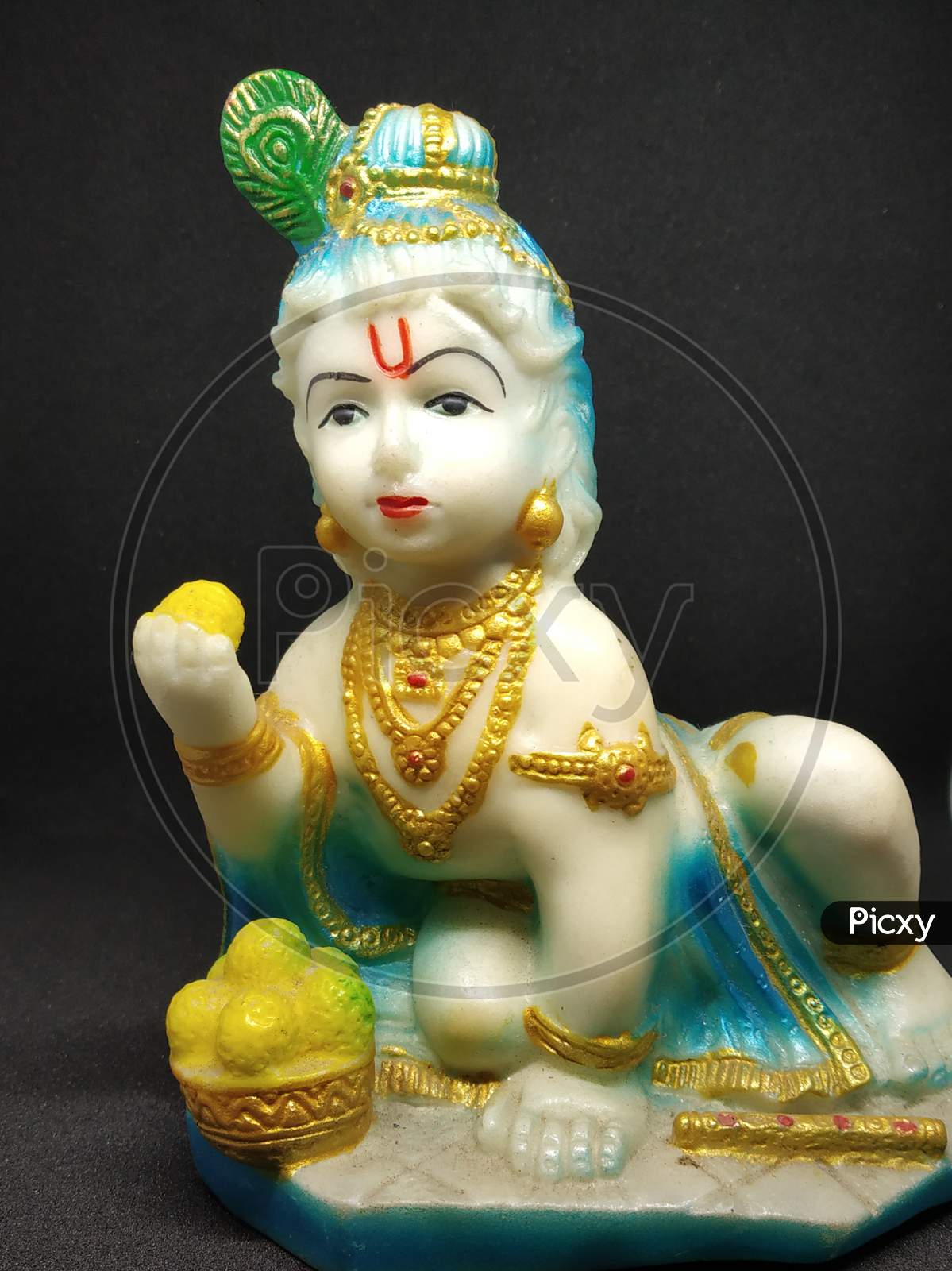 Idol of God Sri Krishna the Indian hindu religious god selectively focused with black background.
