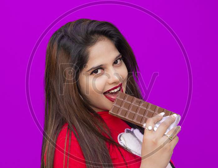 A Beautiful girl eats chocolate and posed with chocolate, Chocolate Day