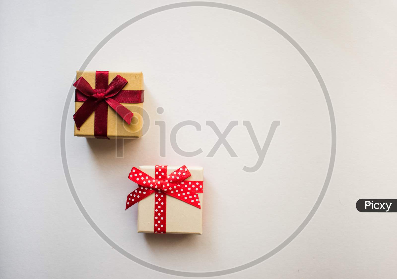 Two Small Gift Boxes With Tied Decorative Bow And Red Ribbon