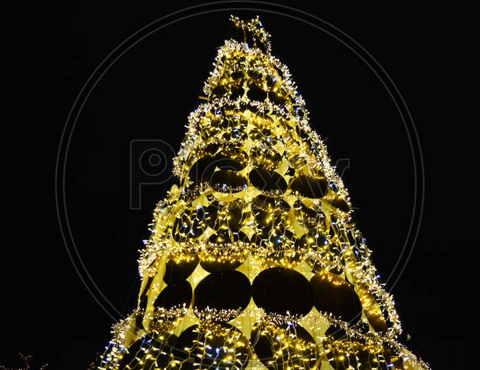 A rich bright golden New Year, Christmas tree with diode lights and sweet candies located in the Globa park in the city of Dnipro, Ukraine.