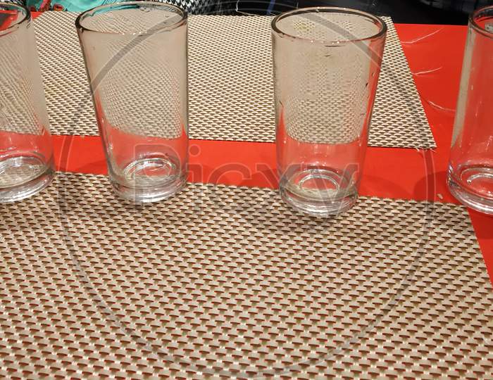 Four Glasses Placed In A Row On A Table In A Restaurant Selectively Focused.